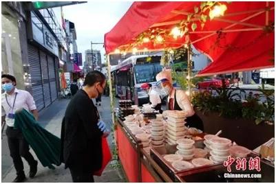 资料图：一家中餐厅在纽约法拉盛社区街道旁外卖菜肴。中新社记者廖攀摄

