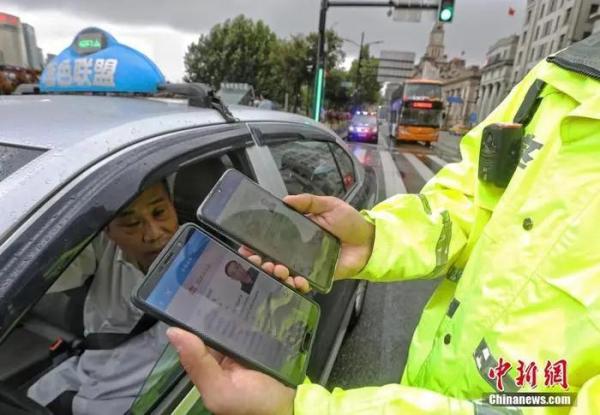 资料图：民警对电子驾驶证进行信息核验。中新社记者 殷立勤 摄